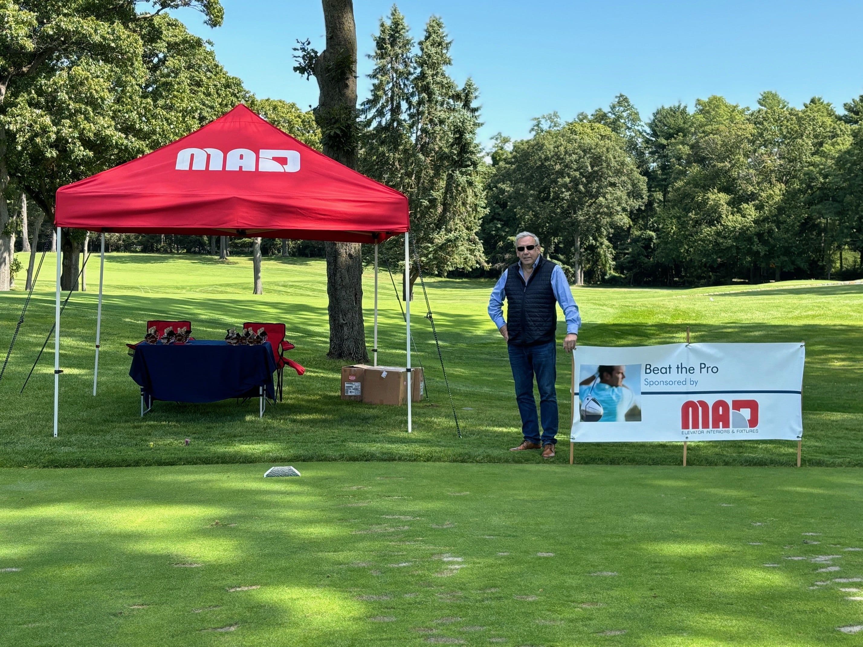 Sales Rep Jonathan Latham standing next to the MAD tent